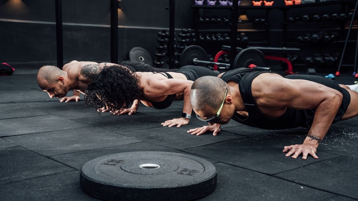 Group workout session in a Mexico City gym with athletes doing push-ups.